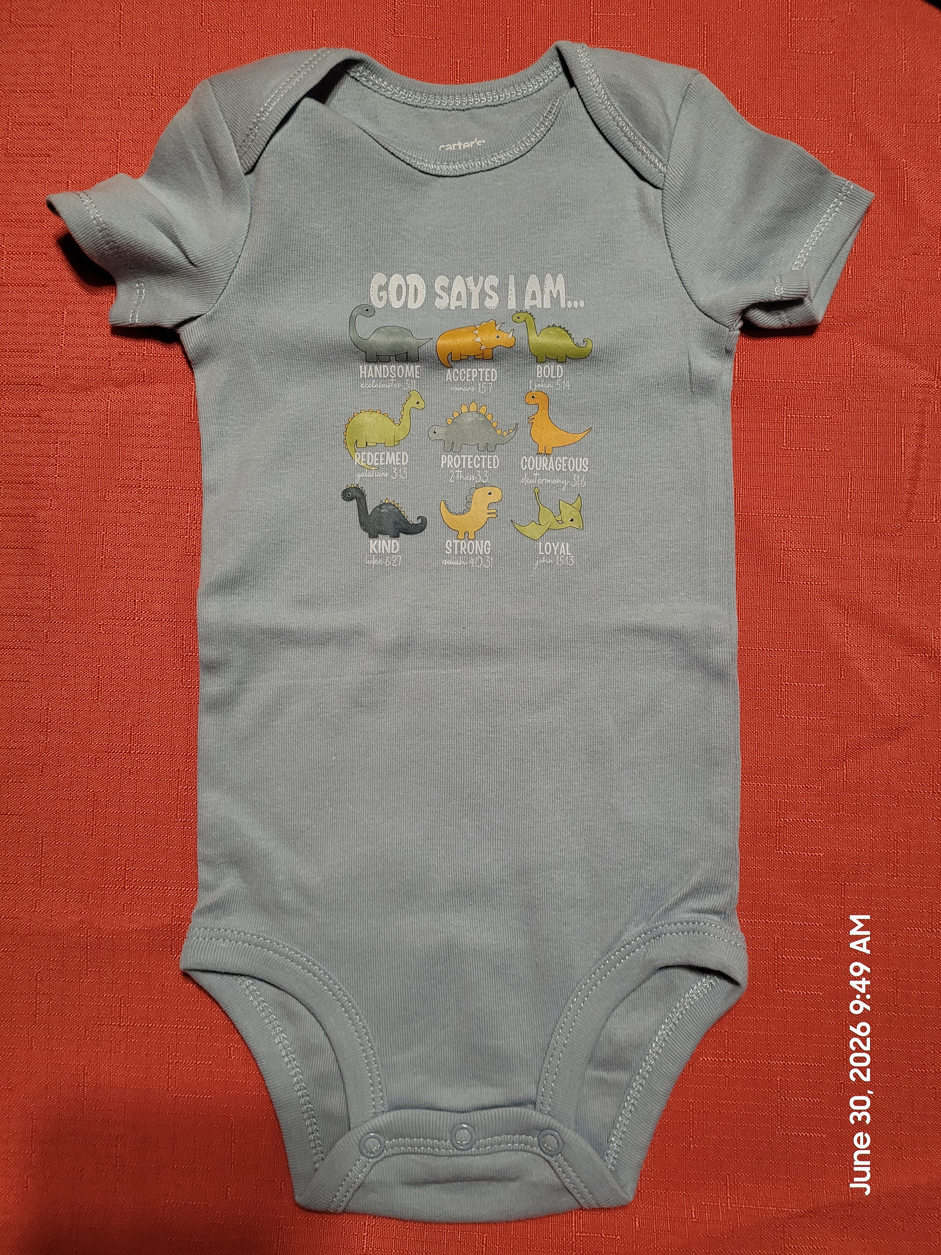 Grey baby onesie with a God Says I Am dinosaur design